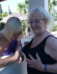 Old women share a lesbian kiss after drinking to much wine out on the patio