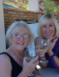 Old women share a lesbian kiss after drinking to much wine out on the patio
